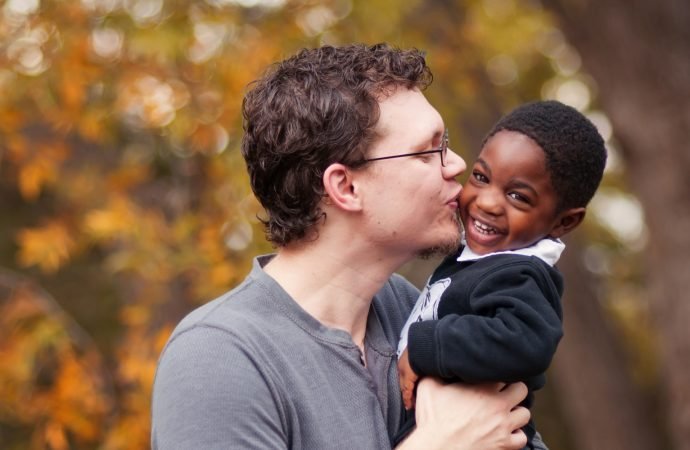 Father kissing adopted toddler son. (Shutterstock via Crux)