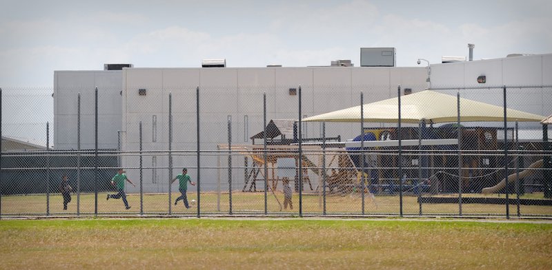 Children play in a double-fenced playground area outside the T. Don Hutto Family Residential Facility in Taylor