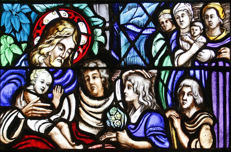 Jesus welcoming children is depicted in a stained-glass window at Our Lady of Lourdes Church in Malverne