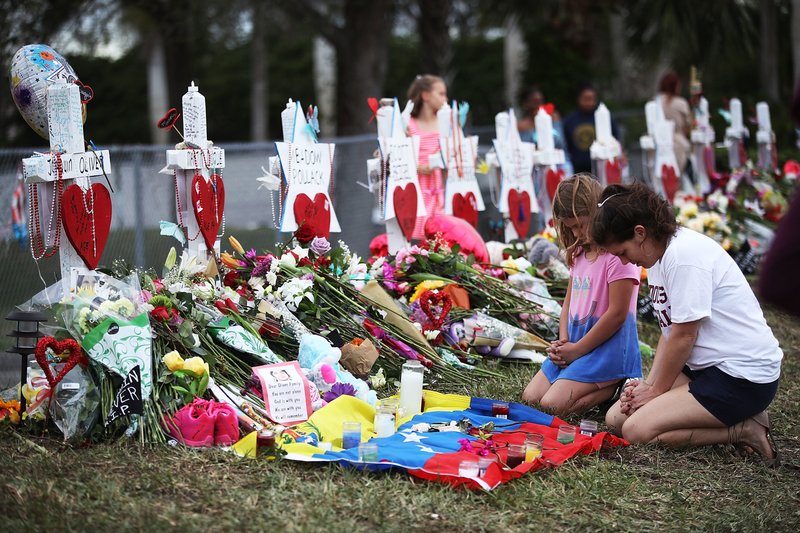 People visit a makeshift memorial setup in front of Marjory Stoneman Douglas High School on Feb. 19 in Parkland