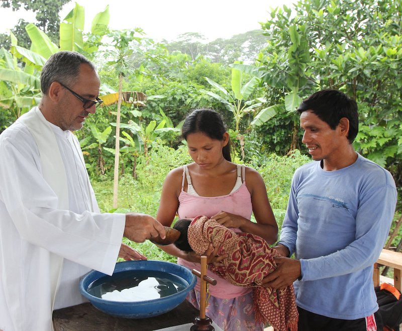 Spanish Augustinian Father Miguel Angel Cadenas baptizes an infant in an Urarina indigenous community on Peru's Urituyacu River June 6