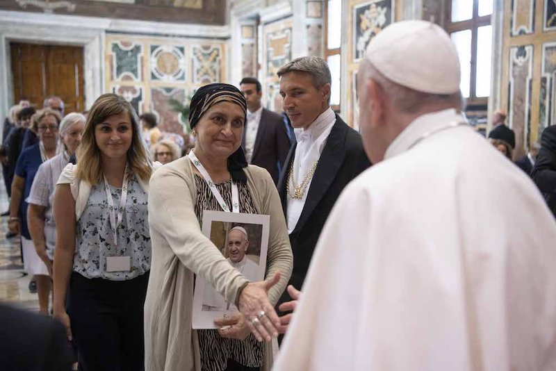 Pope Francis greets an attendee during a meeting with doctors