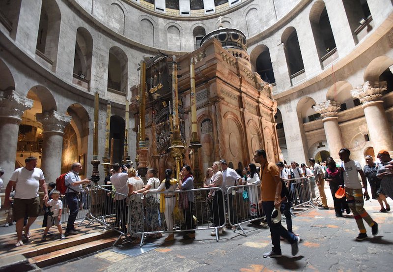 Tourists walk around the tomb in the Church of the Holy Sepulcher in Jerusalem's Old City