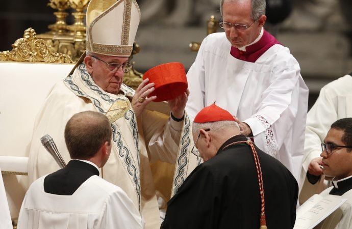 Pope Francis places a red hat on new Cardinal Louis Raphael I Sako