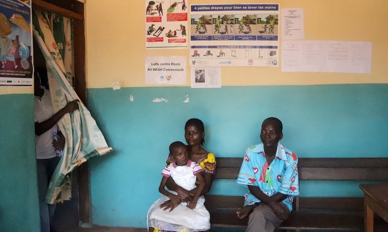 Patients seeking medical attention sit at the health center in Mbandaka