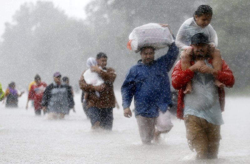 Residents wade through floodwaters from Tropical Storm Harvey Aug. 28 in Beaumont Place