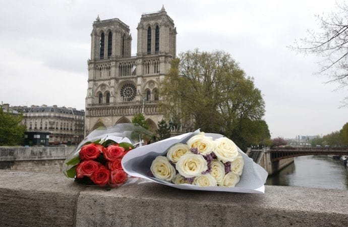 Flowers are seen on the ledge of a bridge near Notre Dame Cathedral April 16