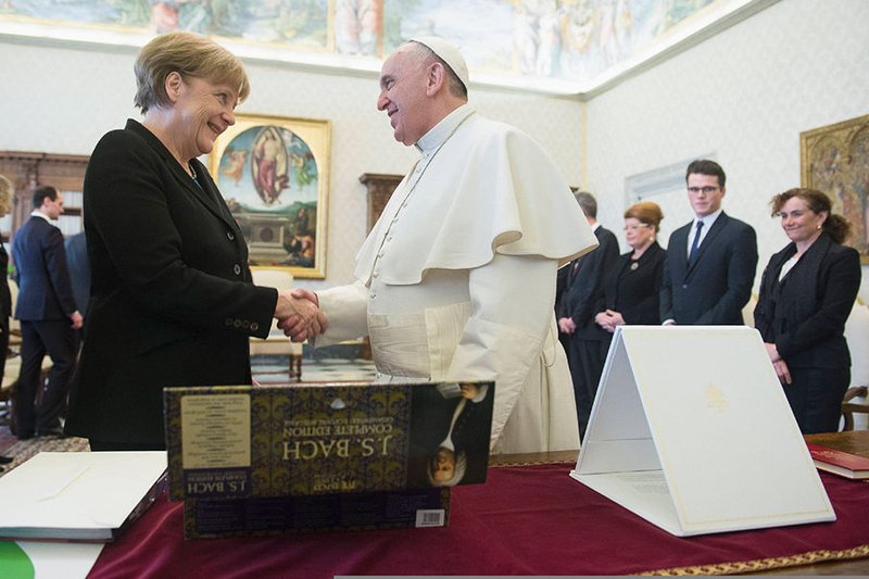 Pope Francis shakes hands with German Chancellor Angela Merkel during a meeting at the Vatican Feb. 21