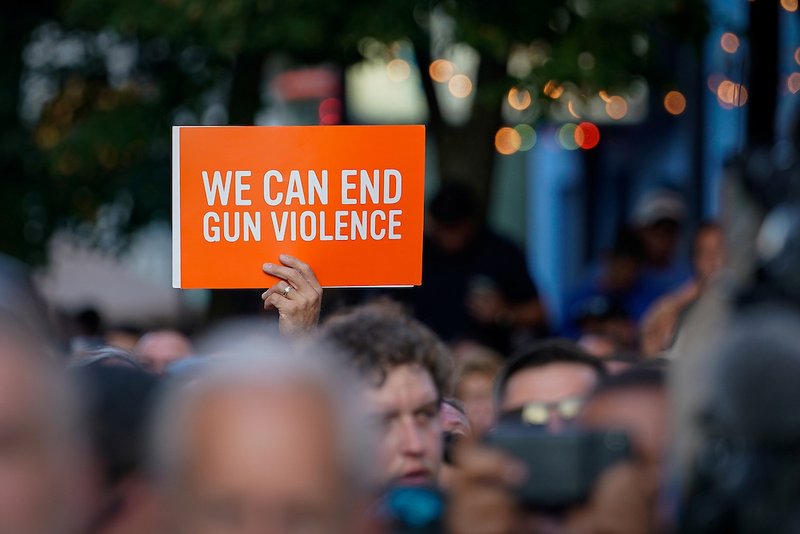 A sign is displayed during a vigil in Dayton