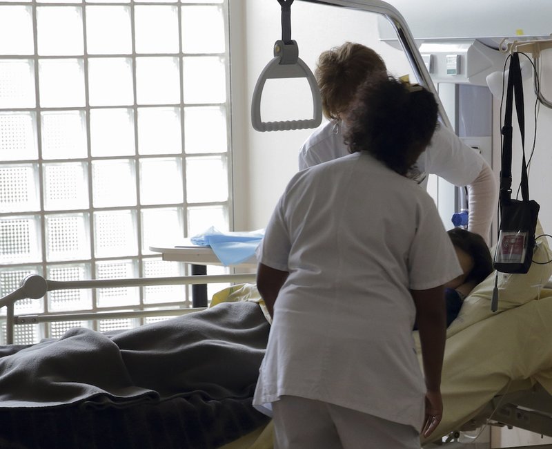 Nurses provide care to a patient in the palliative care section of a hospital. As euthanasia becomes legal in Australia's Victoria state