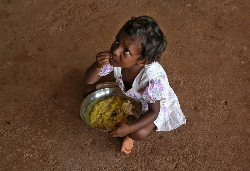 A young flood victims eats a meal inside a temporary relief shelter Aug. 20 in Cochin