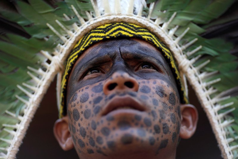 A member of the Shanenawa tribe observes an indigenous dance during a festival to celebrate nature and ask for an end to the burning of the Amazon