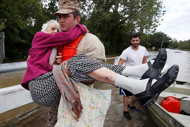 A worker helps an elderly woman from a rescue boat as it evacuates people from the floodwaters of Tropical Storm Harvey Aug. 30 in Houston. (CNS photo/Carlo Allegri