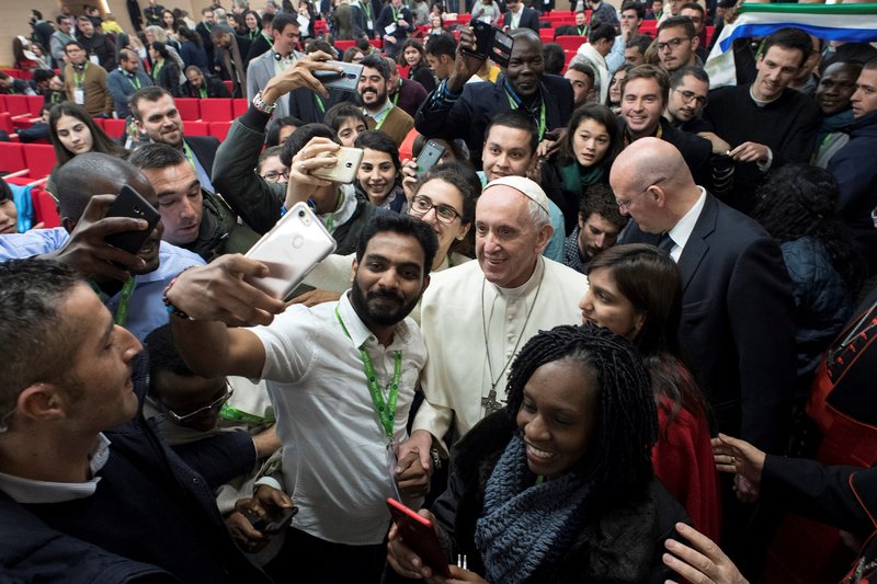 Pope Francis poses for a selfie during a pre-synod gathering of youth delegates at the Pontifical International Maria Mater Ecclesiae College in Rome March 19. The meeting was in preparation for the Synod of Bishops on young people