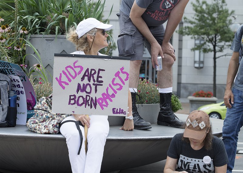 A person holds an anti-racism poster at Freedom Plaza Aug. 12 in Washington prior to the start of the white nationalists' rally "Unite the Right 2" in nearby Lafayette Square. (CNS photo/Tyler Orsburn)