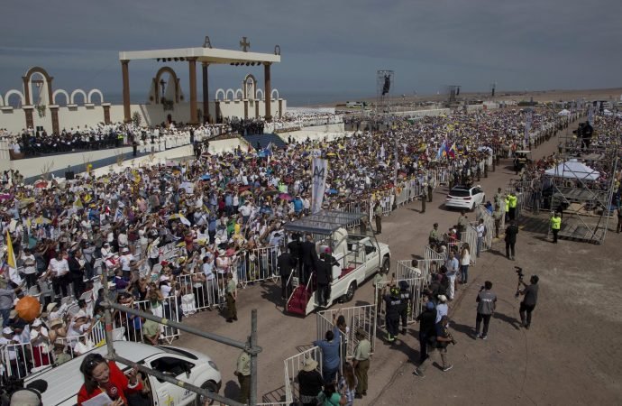 A crowd watches Pope Francis arrive in his pope-mobile to celebrate Mass on Lobito Beach in Iquique