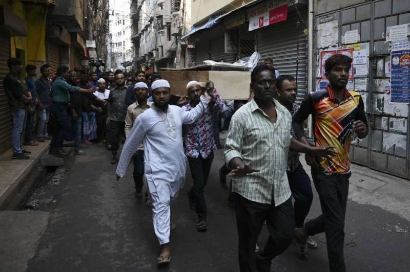 Relatives and residents carry the coffin of a victim during a funeral procession after a fire tore through apartment blocks in Dhaka