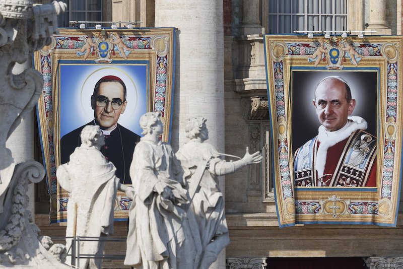 The banners of new saints Oscar Romero and Paul VI hang from the facade of St. Peter's Basilica as Pope Francis celebrates the canonization Mass for seven new saints in St. Peter's Square at the Vatican Oct. 14. (CNS photo/Paul Haring)