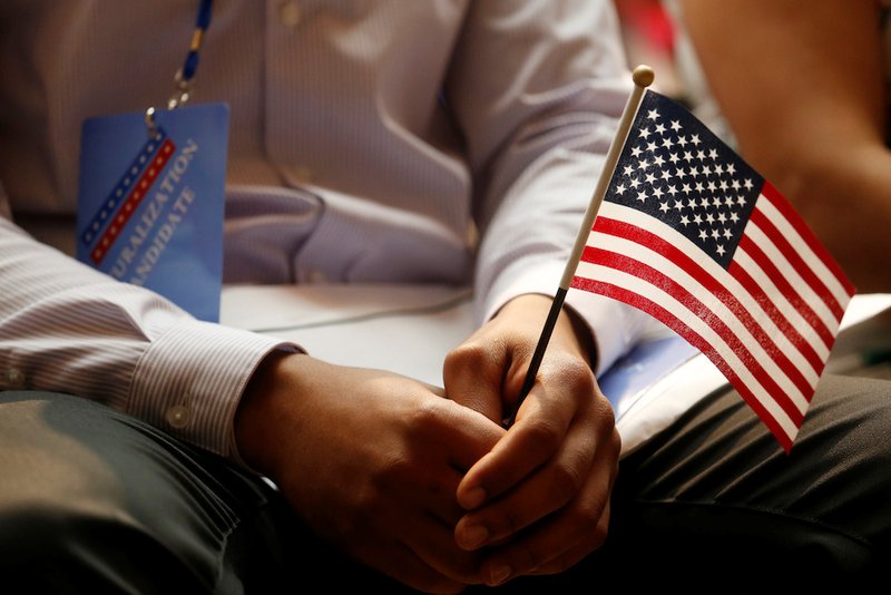 A new citizen holds a flag at the U.S. Citizenship and Immigration Services naturalization ceremony in the Manhattan borough of New York City July 3