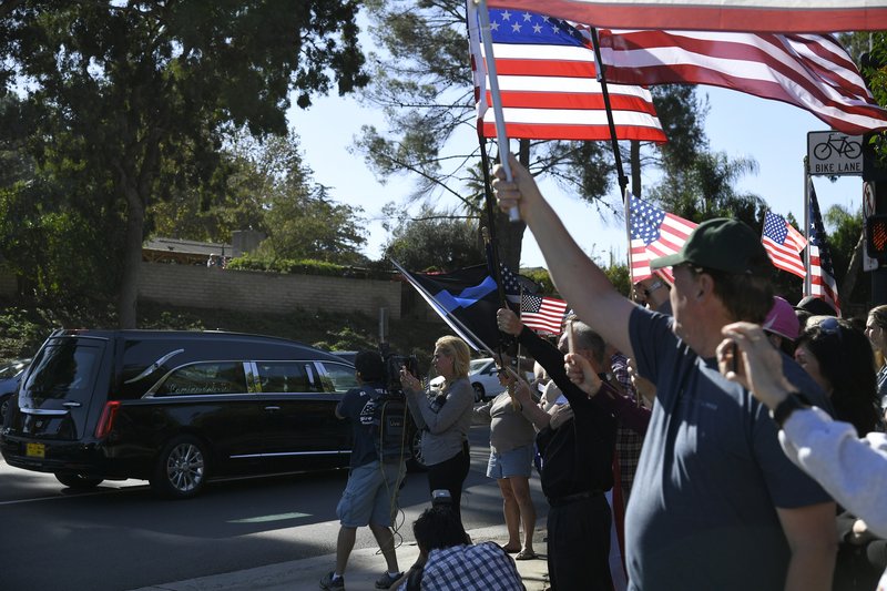 People on Janss Road watch the procession carrying the body of Ventura County Sheriff Sgt. Ron Helus