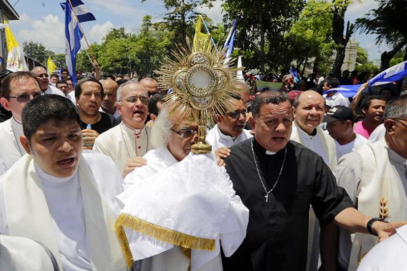 Cardinal Leopoldo Brenes (C) and Catholic leaders attempt to stop attacks by riot police forces