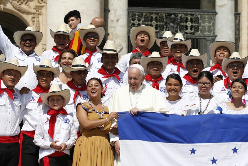 Pope Francis poses with pilgrims from Honduras during his general audience in St. Peter's Square at the Vatican June 5