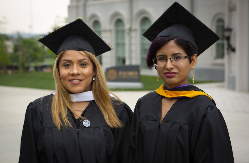 Brenda and Yarely are two of the thousands of Deferred Action for Childhood Arrivals program recipients who are graduating from college this spring in the U.S. The two pose for photos wearing their caps and gowns May 10 at Trinity Washington University. (CNS photo/Chaz Muth)