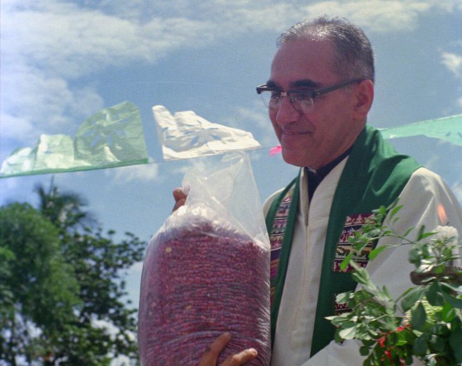 Then-Archbishop Oscar Romero receives a sack of beans from parishioners following Mass outside of a church in San Antonio Los Ranchos in Chalatenango