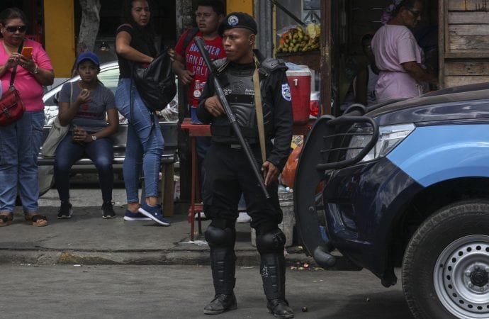 Police stand guard in a neighborhood as negotiations between government and opposition delegations begin in Managua