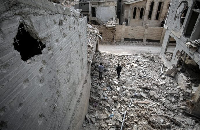 Men walk in rubble Nov. 13 near St. Mary's Catholic Church and St. Elias Orthodox Church after a bombing in Damascus