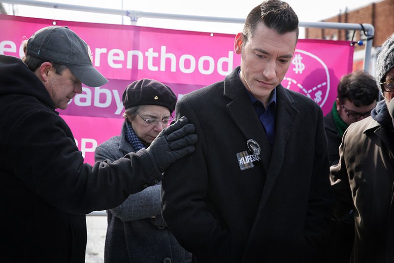 A man prays witth David Daleiden