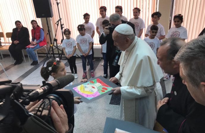 Pope Francis is given drawings from children staying at the Vrazhdebna refugee camp in Sofia