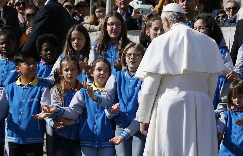 Pope Francis greets a group of children during his general audience in St. Peter's Square at the Vatican March 6