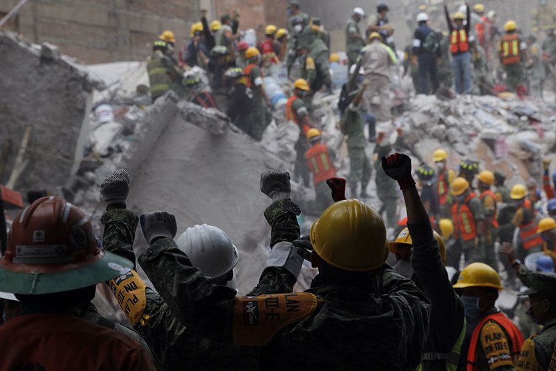 Rescue workers hold their hands up for silence to listen for potential victims in the debris of collapsed buildings Sept. 20 following an earthquake in Mexico City. The magnitude 7.1 earthquake hit Sept. 19 to the southeast of the city