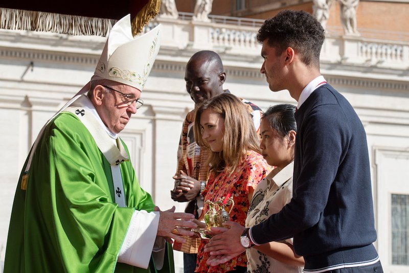 Pope Francis accepts offertory gifts during the opening Mass of the Synod of Bishops on young people
