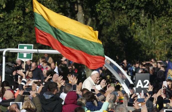 Lithuania's flag is seen as Pope Francis greets the crowd before celebrating Mass at Santakos Park in Kaunas