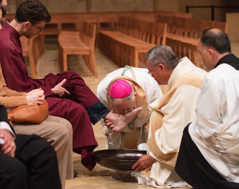 Archbishop Gomez kisses the feet of the faithful during the washing of the feet at Holy Thursday Mass in 2017. VICTOR ALEMÁN