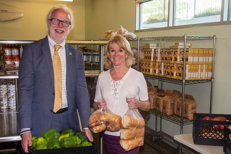 St. Joseph Center (SJC) board chair & president of St. Monica Catholic Schools Kevin McCardle and William H. Hannon Foundation president Kathleen Hannon Aikenhead show some of the food available at SJC's market-style pantry