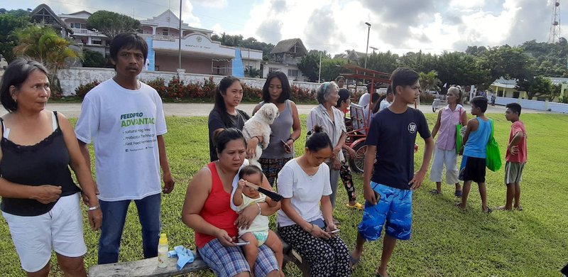 People gather on a field after twin earthquakes struck Batanes province on the northernmost island of the Philippines