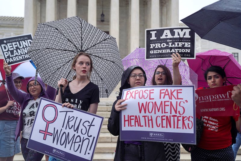 A woman who supports abortion stands alongside pro-life supporters during a June 22