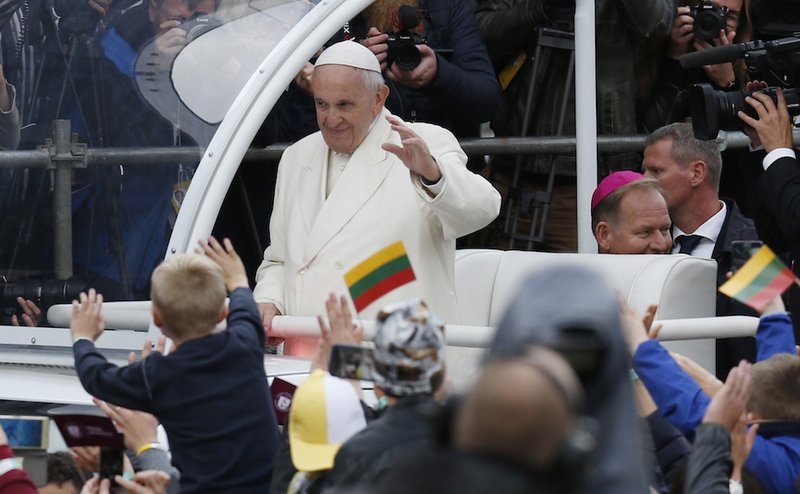 Pope Francis greets the crowd as he arrives for a meeting with young people in the square adjacent to the cathedral in Vilnius