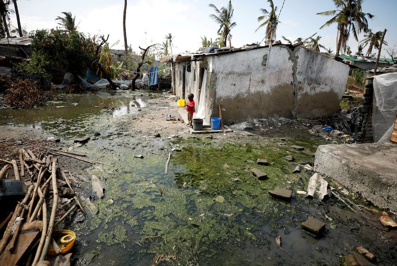 A child stands outside his home in Beira