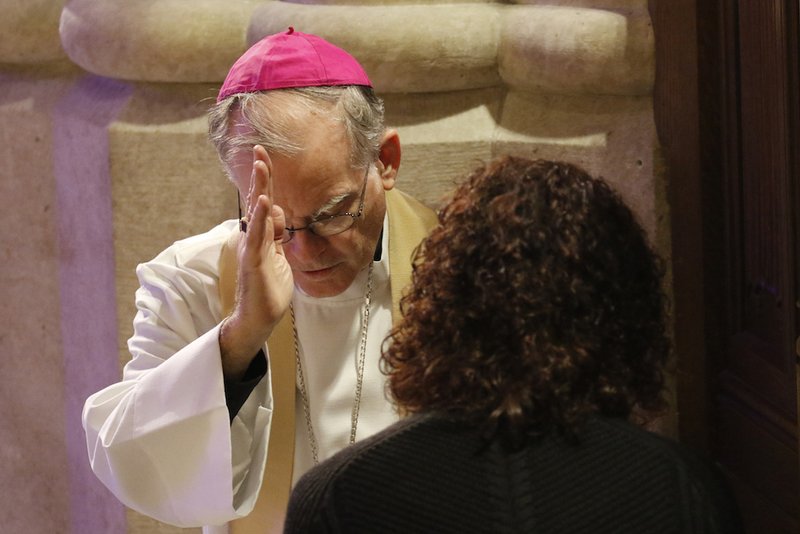 Auxiliary Bishop Peter J. Byrne of New York blesses a woman after hearing her confession at St. Patrick's Cathedral in New York City. (CNS photo/Gregory A. Shemitz)