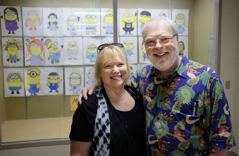 Ron and Tami Clements pose in front of student art work during a tour of Bishop Heelan High School in Sioux City