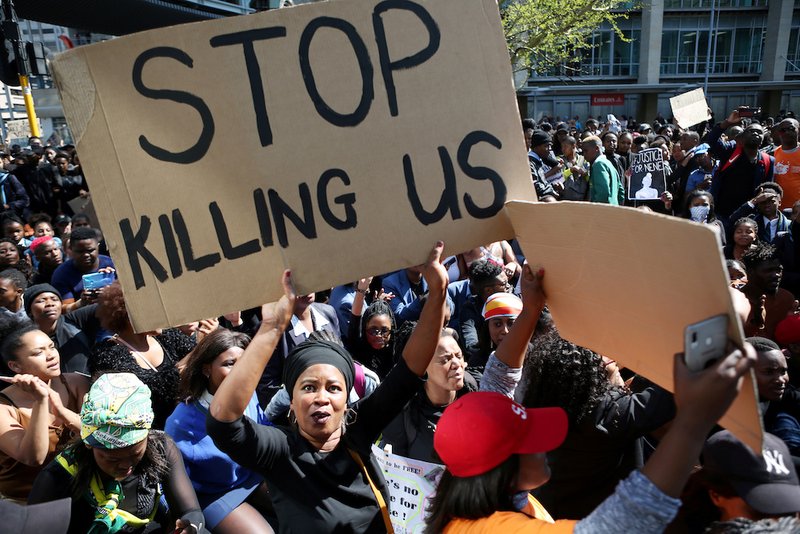 A woman holds a sign as demonstrators gather Sept. 4