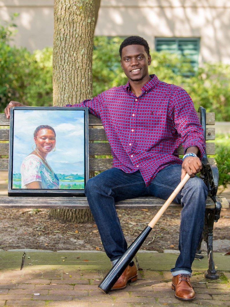 Christopher Singleton poses with an image of his mother Sharonda Coleman-Singleton. (JEFF BLAKE