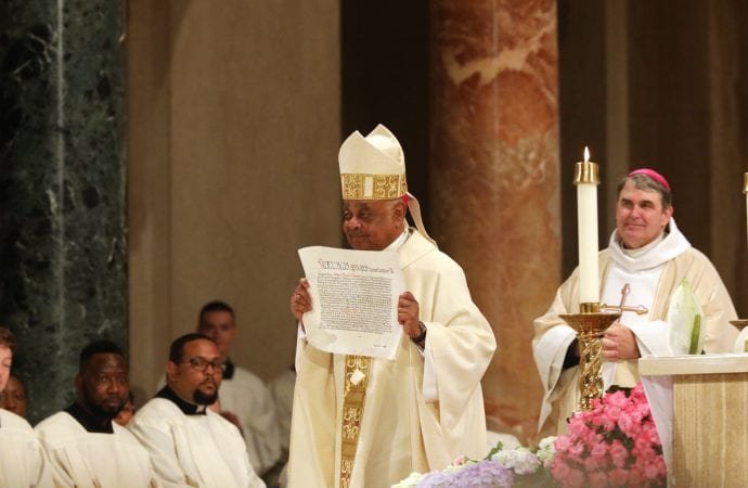 Archbishop Wilton D. Gregory displays the papal bull on his appointment to Washington during his installation Mass at the Basilica of the National Shrine of the Immaculate Conception in Washington May 21