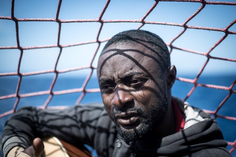 A migrant sits with a guitar aboard the Sea Watch 3 German charity ship off the coast of Lampedusa