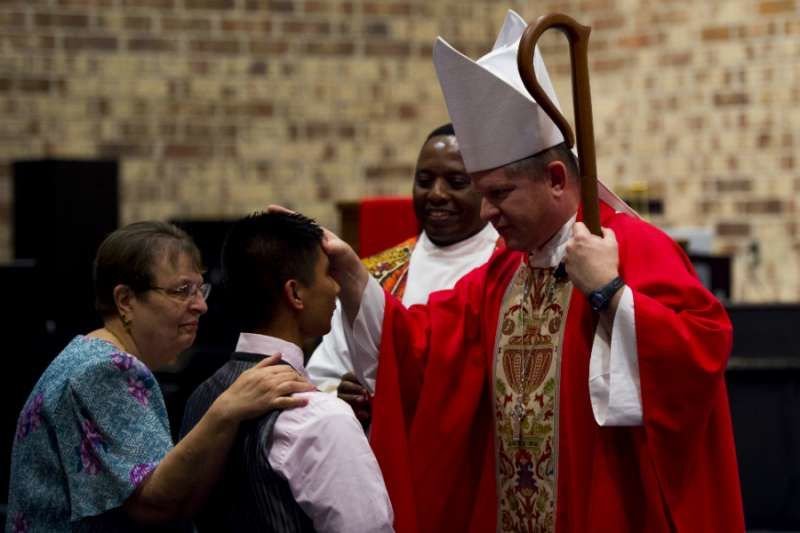 Auxiliary Bishop Robert Coyle gives Confirmation to USAF Airman 1st Class Vernon Bautista at Moody AFB
