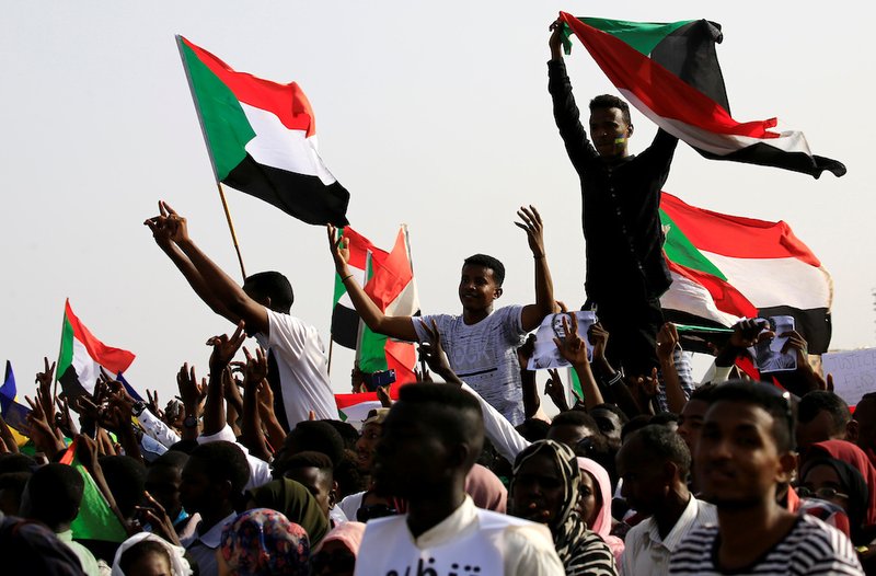 Sudanese shout slogans and wave flags during a rally honoring fallen protesters at Green Square in Khartoum July 18